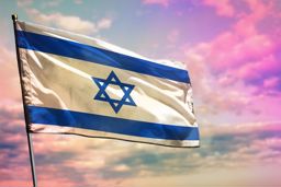 דגל ישראל על נס מתנופף ברוח כשברקע יש שמיים מעוננים בגווני תכלת סגול ולבן