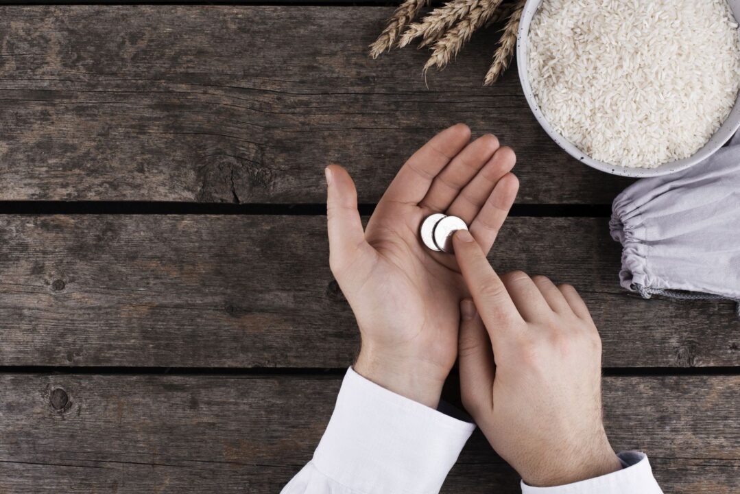 ידיים מחזיקות שתי מטבעות ברקע שולחן עץ