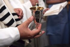 Rabbi holds silver kiddish cup with wine, Jewish Wedding Ceremony