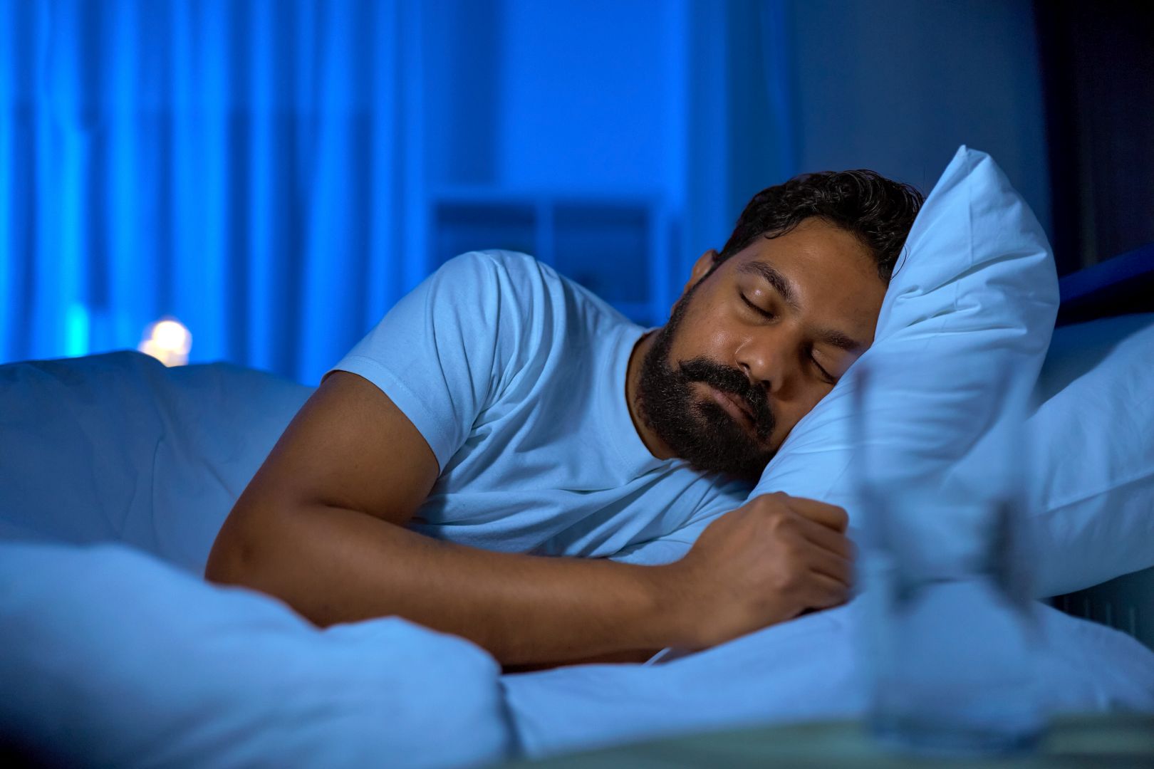 A Man Sleeping In Bed At Home At Night