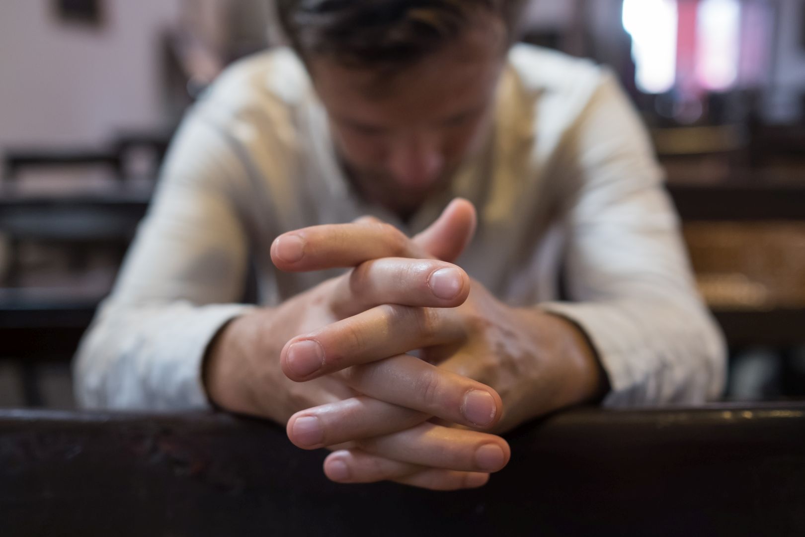 A man prays in a church. He has problems and ask God for help