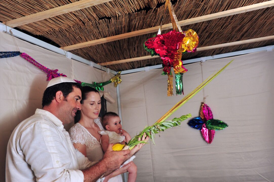 Israeli family bless on the four species in a Sukkah during the Jewish holiday of Sukkot.